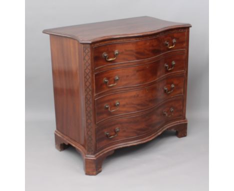 A George III style mahogany serpentine chest of drawers - mid-20th century, with brass swing handles and blind fret carved ca