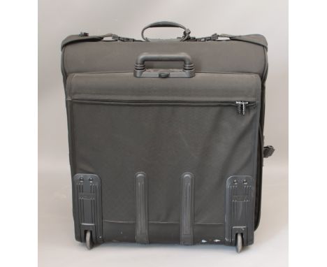 A large TUMI vinyl flight bag - wheeled and with retractable handle, unzipping to fold-out as a suit carrier. (LWH 64 x 43 x 