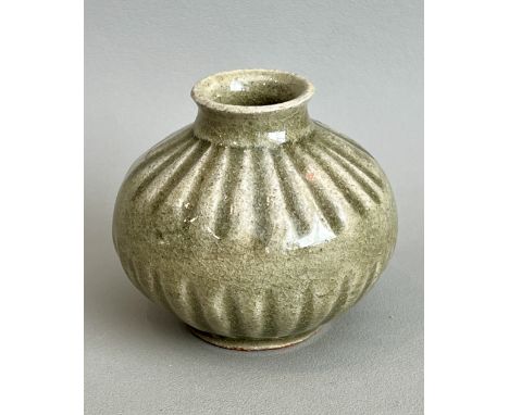 A small Chinese celadon glaze stoneware jar in the Song / Yuan style - of flattened ovoid form with moulded basal and shoulde