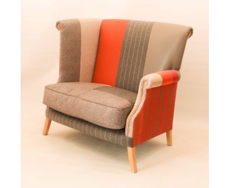 A 'Glimpse Edge' love seat by Artifex - the high back with one high and one low scroll arm, upholstered in a patchwork of stu