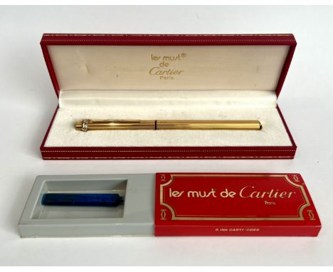 A Must de Cartier gold plated fountain pen - cartridge fill, the case with fluted decoration and tri-colour interwoven band t