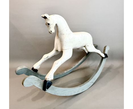 A carved wooden painted rocking horse, requiring restoration - with glass eyes, on bow rockers, 55cm high, 84cm long, 29cm wi