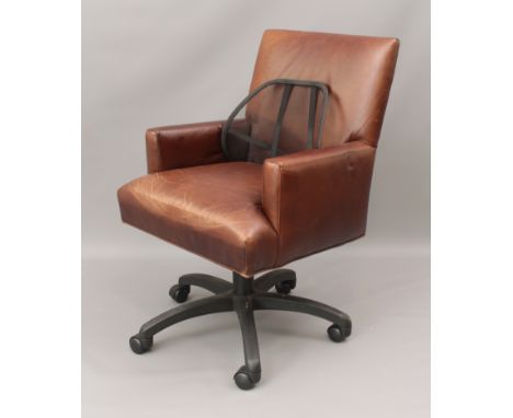 A brown leather revolving office armchair by Crate &amp; Barrel - the tubular support over five spider legs with castors, 63c