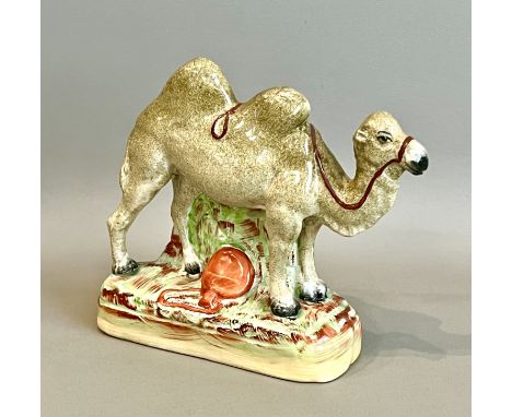 A 19th century Staffordshire flatback figure of a camel - sponge painted in colours to the back and front with a naturalistic