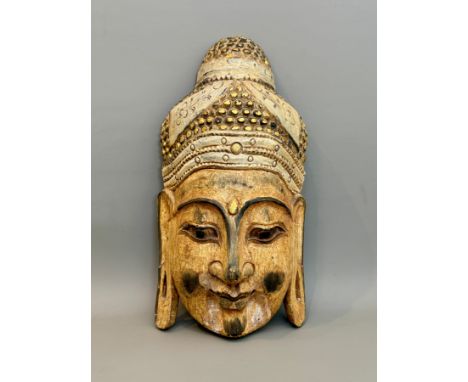 An Indian carved and painted wooden mask of Buddha - 49.25cm high.