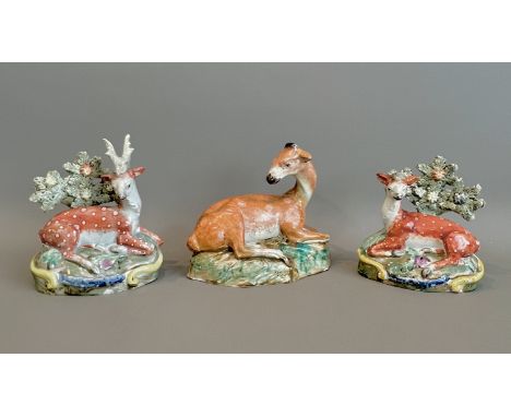Three Staffordshire pearlware figures of a stag and deer - comprising a stag and doe pair, modelled in a recumbent pose with 