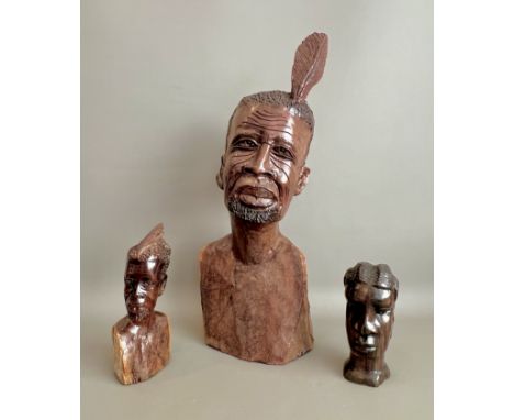 An exceptionally large, heavy and sculptural African carved hardwood bust - depicting an elder wearing a feather in his hair,
