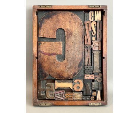A tray of early 20th century carved wooden printer's block letters - the largest a 'G', 29.5 x 20.2cm, in a mahogany tray, 31