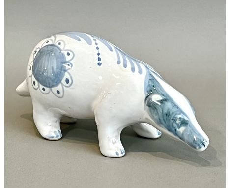 A David Sharp at Rye Pottery figure of a badger - signed to underside, glazed in soft blue and white with flowers and leaves,