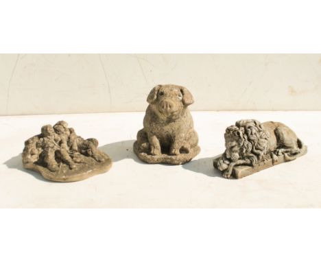 Three reconstituted stone garden ornaments - the seated piglet 21.5 cm high  
