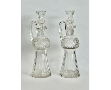 A pair of cut glass thistle-shaped whisky decanters - first half 20th century, with panel and diamond cut decoration, pouring