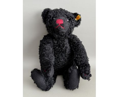 A Steiff Classic teddy bear, yellow tag 005985 - in black mohair, with boot button eyes, red stitched nose, mouth and claws, 