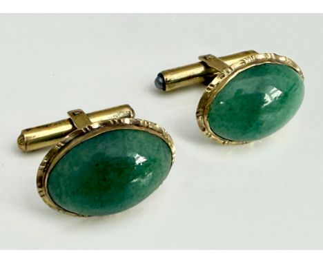 A pair of 14ct yellow gold and green jade-style hardstone cufflinks - stamped '14K', the 18 x 13mm cabochon stones within cri