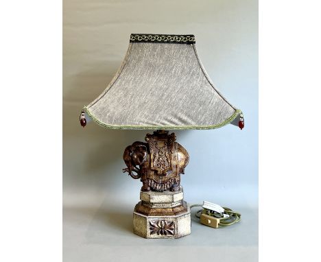 A decorative elephant table lamp - the moulded composition lamp in the form of a elephant with howdah on an octagonal plinth,
