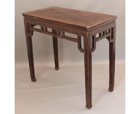 A tall Chinese stained elm centre table - first half 20th century, the cleated rectangular top over a fretwork frieze, raised