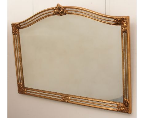 A modern arched gilt mirror - with foliate cresting and spandrels and aged marginal plates to the frame, 90 x 129cm.