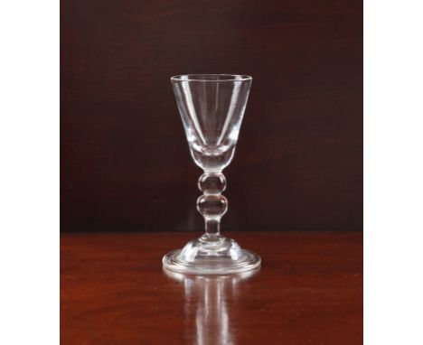 A small baluster wine glass - probably 18th century, the round funnel bowl seated on a collar knop and baluster stem, to a do