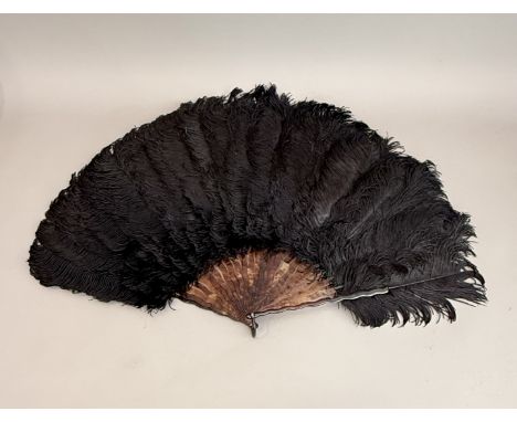 A vintage ostrich feather fan - 1920s, the black feathers on faux-tortoiseshell early plastic sticks, in good condition, 40.7