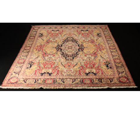 A Persian hand-knotted wool rug - second half 20th century, the dark-blue and ivory ovoid medallion on a mustard-yellow and r