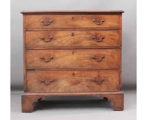 A Regency mahogany straight-front chest of drawers - the crossbanded top over four long graduated drawers with the original b