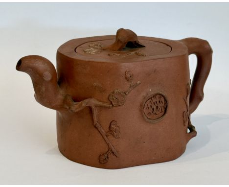 A Chinese Yixing red clay teapot - 19th century, of naturalistic branch form, moulded with prunus branches in relief, two cha