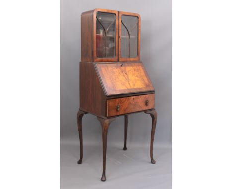 A 1930s figured walnut bureau bookcase - the bookcase top with a pair of three-pane astragal glazed doors, enclosing a single