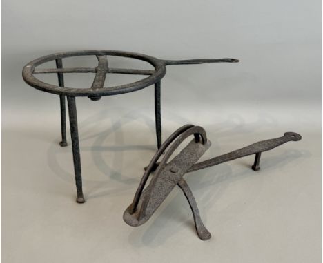 Two antique wrought iron down-hearth trivets - comprising a circular trivet on tall tripod supports, 21cm high, 41.5cm long; 