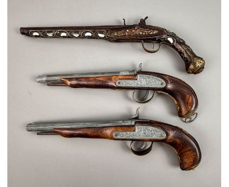 A late 19th century (possibly North African) flintlock pistol with ornate decoration and a pair of early 20th century percuss