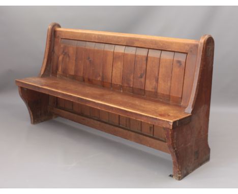A Victorian stained-pine church pew, originally from St Lawrence Church, Bourton-on-the-Water - the round topped crest rail o