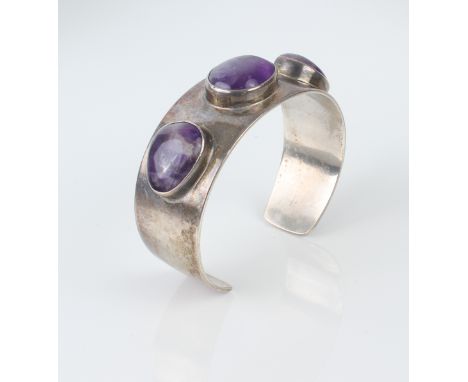 Arne Johansen: a Danish sterling silver and amethyst bangle - stamped 'Denmark AJ 925S', the broad band with three oval caboc