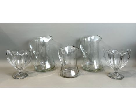 A pair of mid-20th century large clear glass lemonade jugs - with pinched spouts and ground pontils to the base, 27.8cm high;