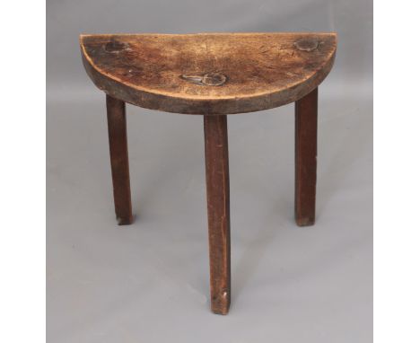 An antique provincial tripod milking stool with half moon seat - in walnut with beech and oak tapered supports. (LWH 45.5 x 2