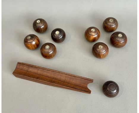 A set of eight 19th century turned wooden carpet bowls - 36mm diameter, together with a jack and later launching ramp.