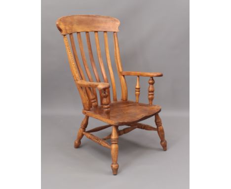 A late-19th century beech and elm lathe-back low armchair - saddle seat; spindle arm supports, stretchers and legs (possibly 