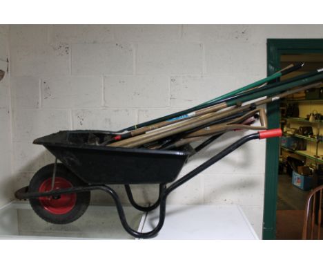 A wheelbarrow containing a quantity of garden tools 