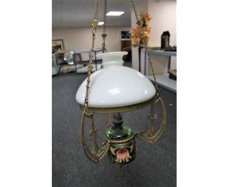 An antique brass and china hanging oil lamp with green glass reservoir, chimney and shade 