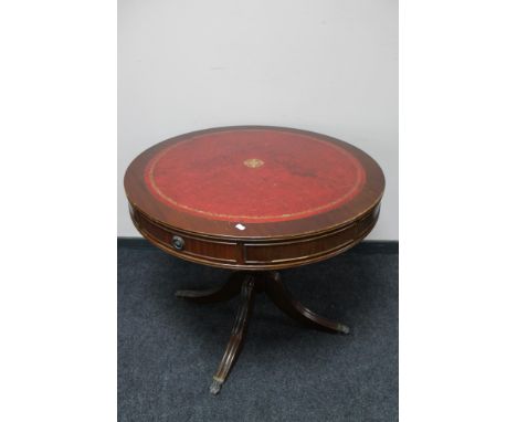 A mahogany pedestal drum table with red leather inset panel 