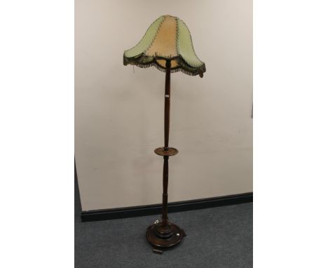 An early 20th century oak standard lamp and shade 