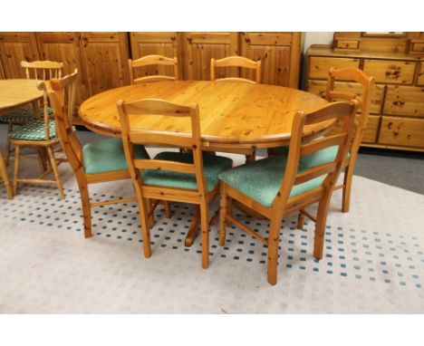 A circular pine extending pedestal table and six ladder back chairs 