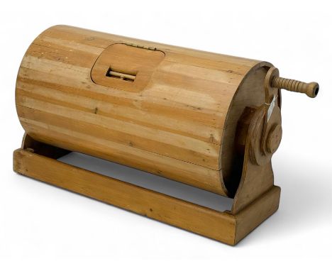 20th century pine tombola, of barrel form with hinged access hatch, mounted on a rectangular plinth base, operated by a turne