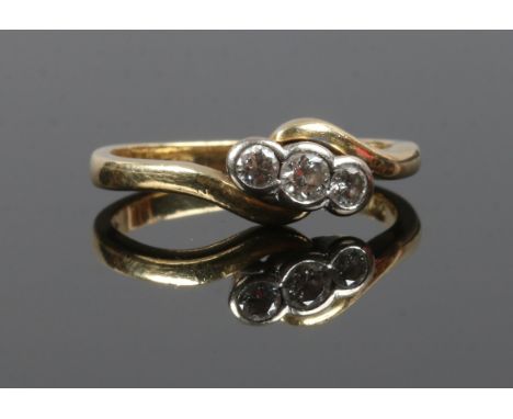 An 18ct gold three stone diamond crossover ring. Total weight approximately 0.25ct. Size K.