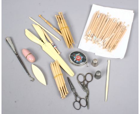 A box of vintage sewing tools including glove stretchers, thimbles and crochet hooks etc.
