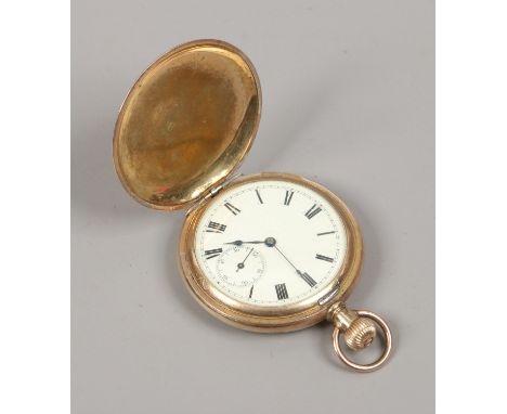 A vintage gold plated full hunter pocket watch with white enamel dial, Roman numeral markers and subsidiary seconds.