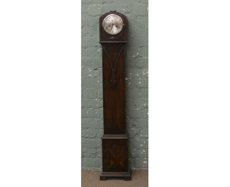 An oak cased granddaughter clock chiming on a coiled gong.