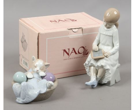 A boxed Nao model of a cat in a basket along with a Nao model of a school girl. 
