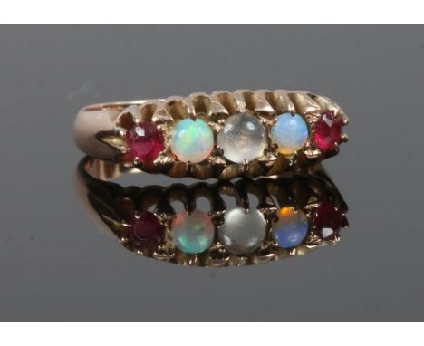 A 9ct gold ring set with opals, rubies and a moonstone in a boat shaped setting. Size N.