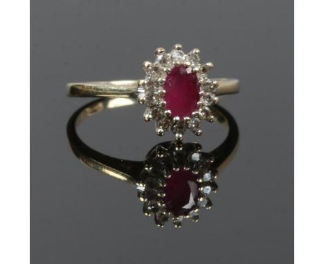 A 9 carat gold ruby ring halo set, bordered by diamonds, size L 1/2 gross weight 2.3 grams.