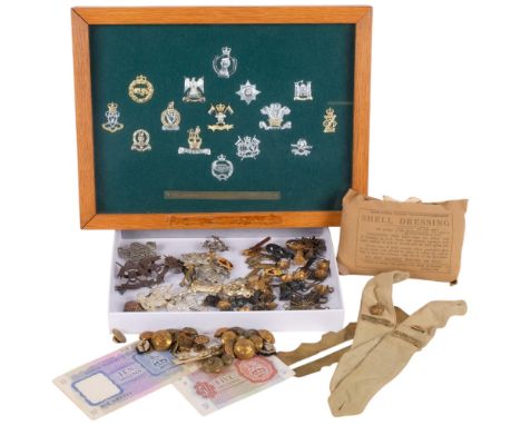A framed collection of collar badges of the Royal Armoured Corps, a shell dressing, a British Military Authority five and ten
