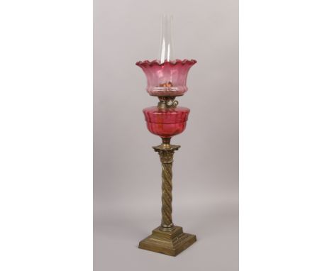 A large Victorian brass based oil lamp with ruby glass shade and font.Condition report intended as a guide only.Possibly made