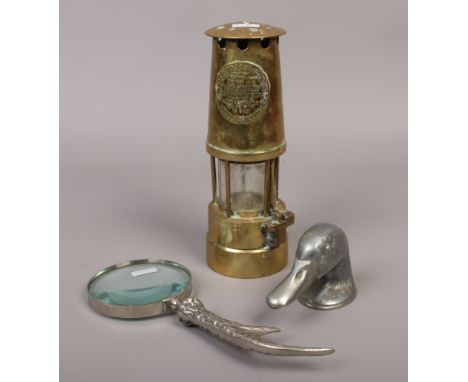 An Eccles coal miners safety lamp along with metal antler shaped magnifying glass and a model of a ducks head.